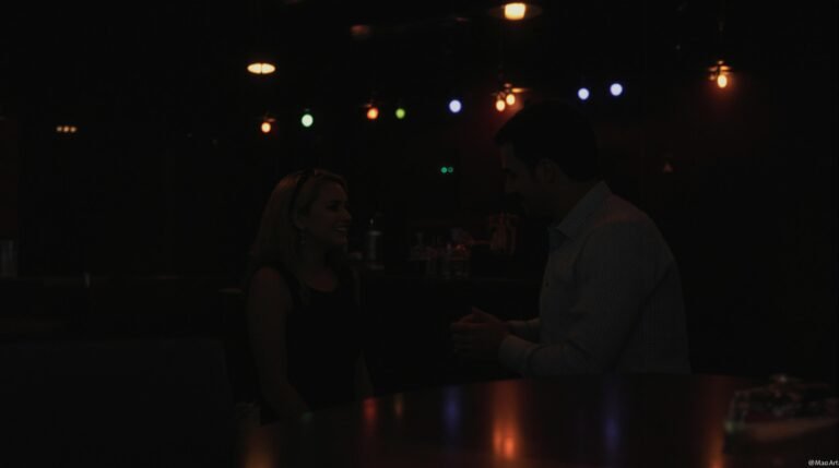 Couple talking at a dimly lit bar.